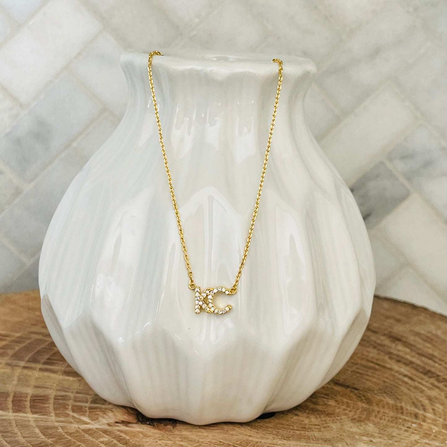 A little bit of KC love to take with you wherever you go. represent your hometown with this KC Rhinestone necklace. A simple and delicate design, this necklace is perfect for everyday wear. With its easy-to-wear style, this necklace is a must-have for any KC lover.   KC Rhinestone Necklace 18K gold plated 18 inch necklace with 3 inch extender