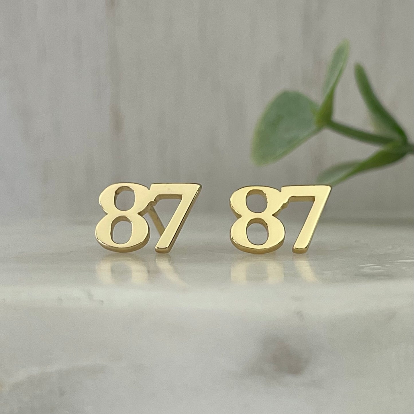 18K gold plated 87 stud earrings These earrings are perfect for the Kelce fan in your life! These beautiful earrings feature the number 87 and are perfect for any fan of the Chiefs. They make the perfect addition to any game day outfit and add a little bit of team spirit to your look. So whether you're heading to the stadium or just out on the town, show your team spirit with these gold stud earrings.