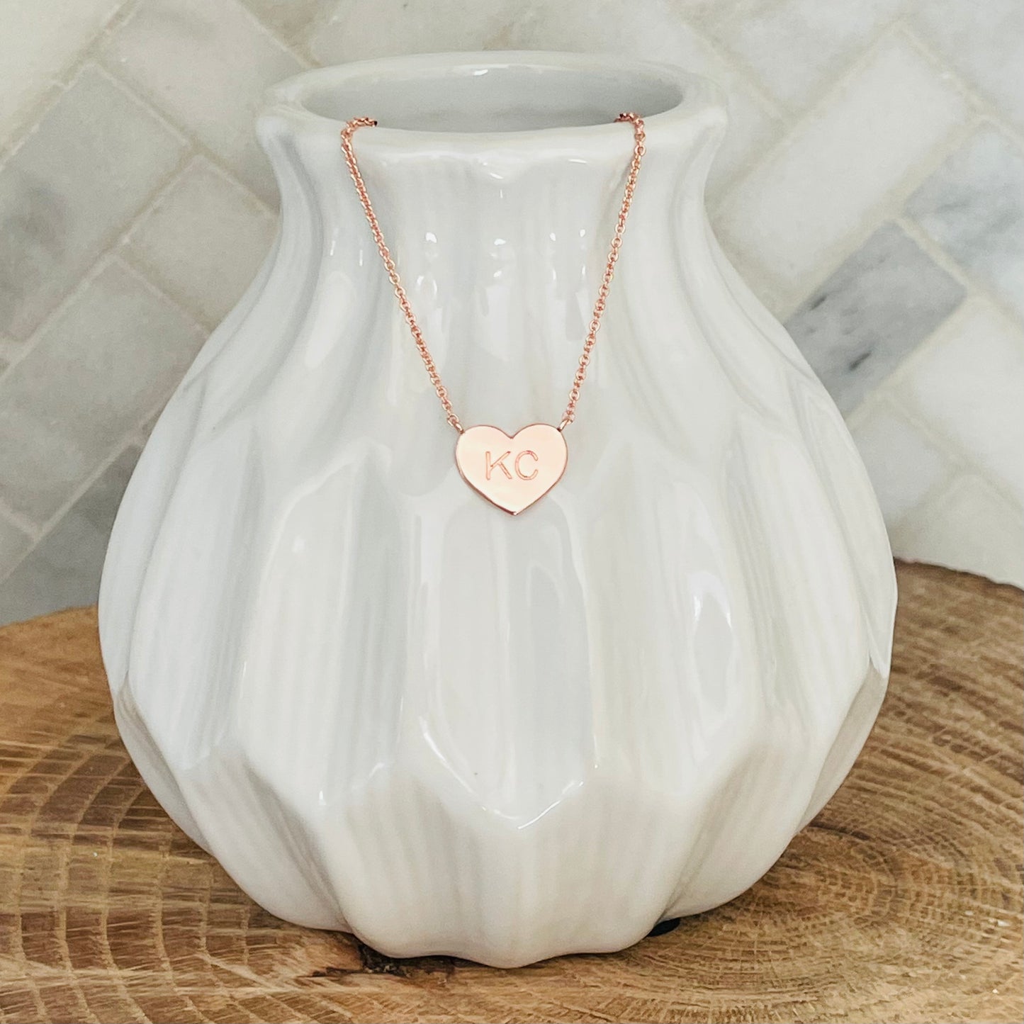 A little piece of Kansas City love. This KC necklace is the perfect way to show your love for your home town. With its simple and elegant design, the KC necklace is a must-have for any KC lover. The KC necklace makes the perfect gift for any occasion. Give the gift of love with the KC necklace.   KC Heart Necklace Rose Gold 18K rose gold plated 18 inch necklace with 3 inch extender