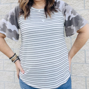 This top is the perfect blend of fun and flirty. The camo print is perfect for any day, while the stripes add a touch of playfulness. The short sleeves are perfect for those warmer days. Whether you're running errands or going out with friends, this top is a must-have for your wardrobe.  63% Poly | 34% Rayon | 3% Span