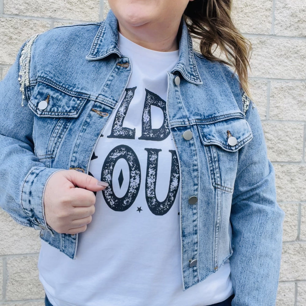 
                  
                    Elevate your style with this edgy denim jacket. With rhinestone details on the sleeves, this jacket will turn heads wherever you go. The distressed hemline gives it a unique edge that you'll love. Perfect for a night out or for everyday wear, this jacket is a must-have in your wardrobe.  Details Rhinestones details on sleeves Cropped Distress hemline 87% Cotton | 8% Poly | 5% Viscose
                  
                