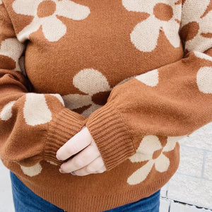 A little bit of daisy love for your wardrobe. This soft and cozy sweater is perfect for keeping you warm and cozy. With an all-over daisy print, it's a fun and stylish addition to your wardrobe. Layer it under a shacket or wear it on its own. No matter how you style it, this sweater is sure to keep you comfortable and stylish all season long.  Details Daisy All Over Print Color Brown Cozy Sweater Loose Fit