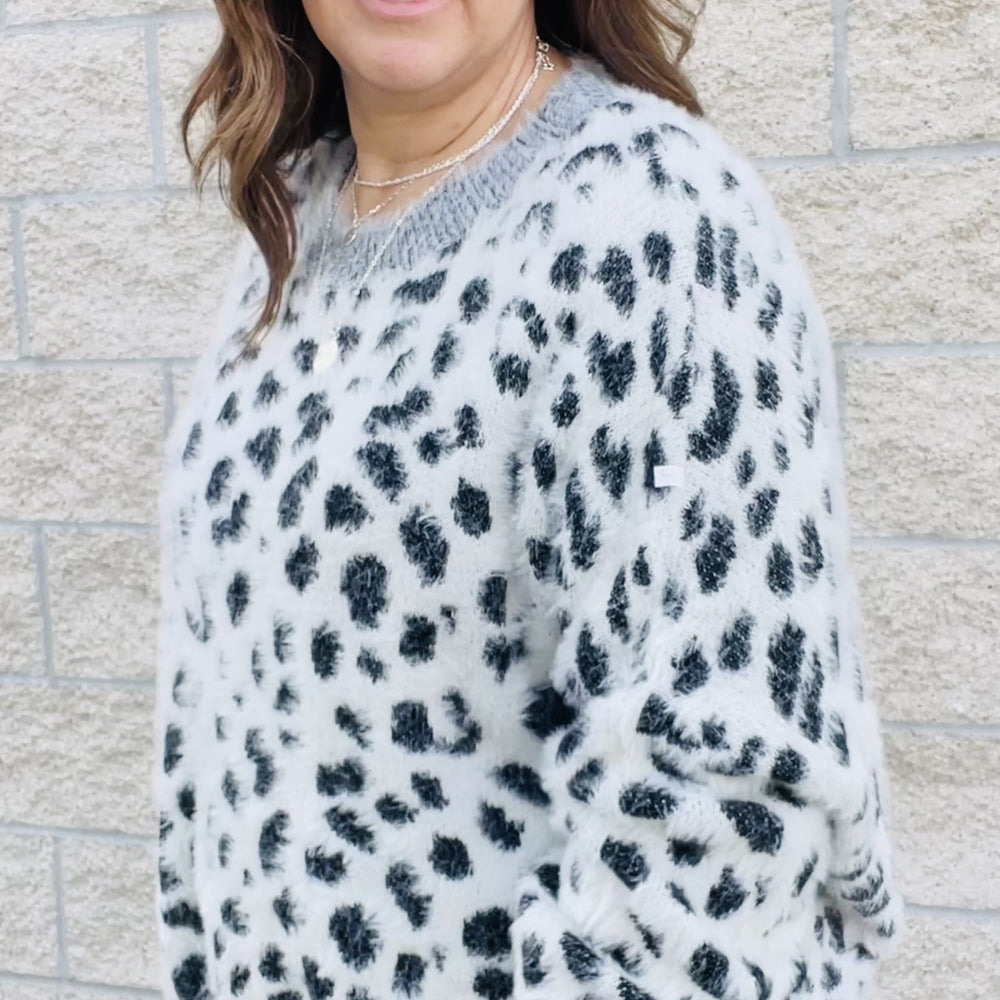 Add a bit of wildness to your style. This black and white leopard print sweater is the perfect way to add a touch of fun to your wardrobe. With its wide sleeves and soft, cozy fabric, it's perfect for chilly days. Match it with your favorite jeans or dress it up with a skirt. No matter how you wear it, you'll love the leopard print sweater.  Details Leopard Love Relax Fit Wide Sleeves Comfy and Cozy Color Black and white with gray trim
